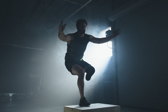 Adaptive athlete exercising on box in gym