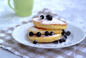 Pancakes with corn flour, sprinkled with powdered sugar and berries