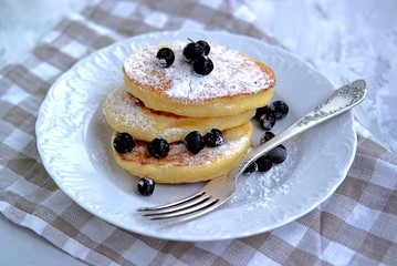 Pancakes with corn flour, sprinkled with powdered sugar and berries