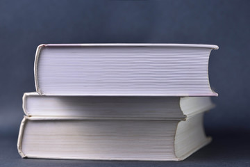 Stack of heavy books on gray background