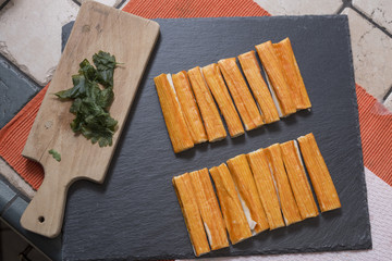 preparation of fish sticks with crab meat on slate plate