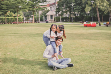 Fototapeta premium Family Concept. Happy male and female playing with children outside. Family is doing happy activities at Playground. Parents are playing happily.