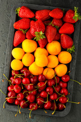 Fresh ripe summer berries and fruits (apricots, cherry and strawberry) 