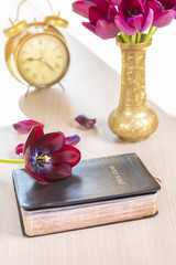 Holy Bible with flowers on wooden table