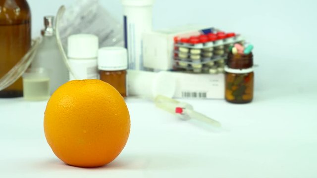 Fresh orange fruit and colorful pills on white table