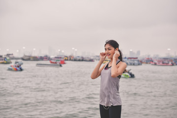 Sports concept. Beautiful girl is exercising on the beach with warm up. Beautiful girl is happy to exercise.