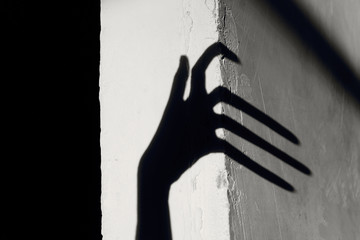 Strange Shadow On The Wall.Terrible Shadow. Abstract Background. Black Shadow Of A Big Hand On The Wall. Silhouette Of A Hand On The Wall. Nightmares. Scary Dreams.

