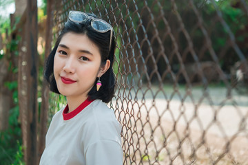 Portrait of beautiful asian chic girl pose for take a picture on the fence,Lifestyle of teen thailand people,Modern woman happy concept