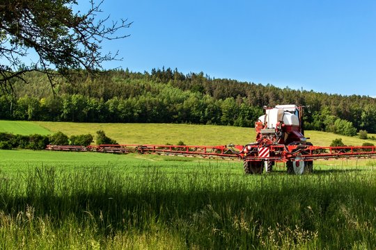 Field spraying tractor. Agricultural work on a farm in the Czech Republic. Spraying against pests.
