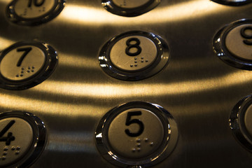 several stainless steel elevator panel push buttons, metal buttons in the Elevator, selective focus
