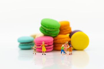 Fototapeta na wymiar Miniature people : children playing together front sweets. Image use for happy family day concept.
