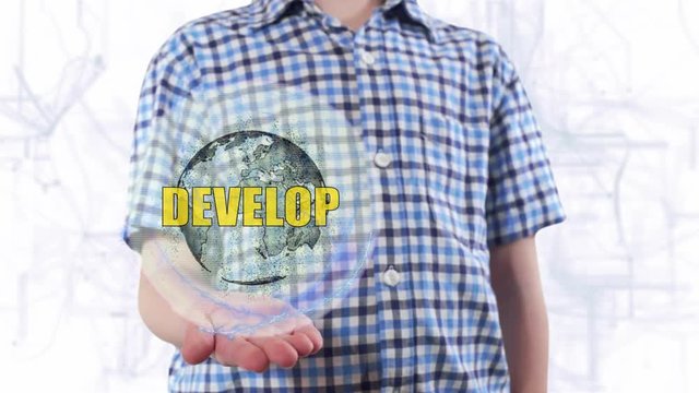 Young man shows a hologram of the planet Earth and text Develop. Boy with future technology 3d projection on a modern white digital background
