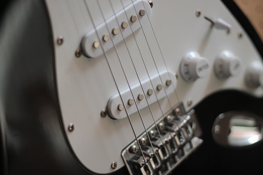 Closeup of pickups on white six string electric
