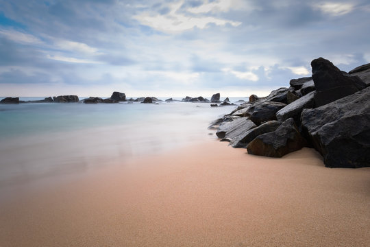 A seascape with clean sand and water in Sri Lanka. Long exposure