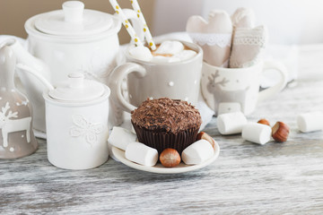 Cups with cacao and marshmallow, cupcakes and different decorations