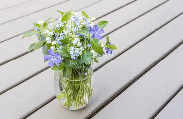Bouquet of Spring Flowers in a Wine Glass Placed on a Wooden Deck