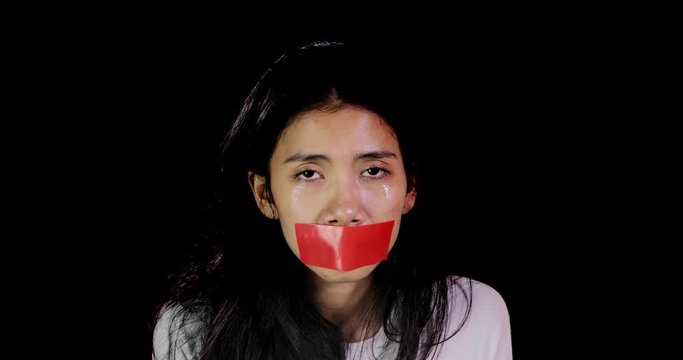 Scared woman with closed mouth using adhesive tape looks sad and crying. Shot in 4k resolution