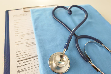 A stethoscope shaping a heart on a medical uniform, closeup, selective focus