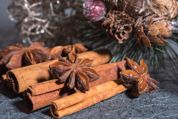 Cinnamon sticks, star anise and christmas ornaments close up