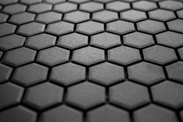 Ceramic tiles mosaic made of gray rhombuses, without grouting, the mesh-base and glue is visible. The concept of repair. Background. View in perspective.