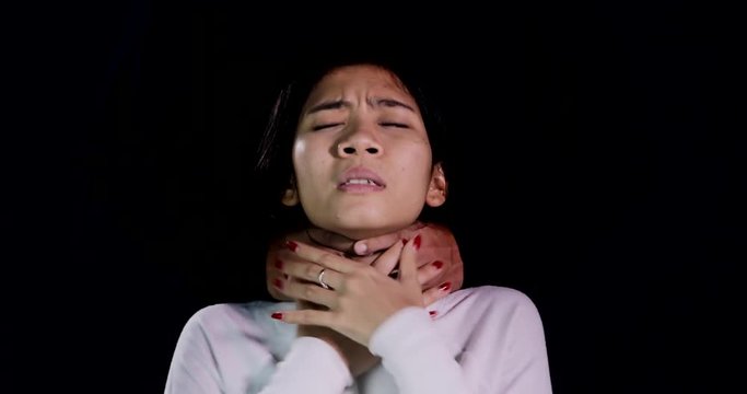 Young woman being strangled by a male criminal for unknown purposes over dark background. Shot in 4k resolution