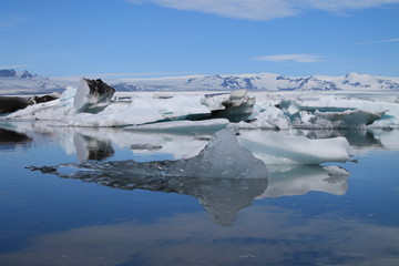 Island - Jökursarlon, bläulich schimmernde Eisberge auf schwarzen Strand, angespült vom Meer