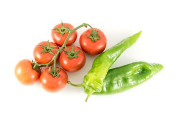 tomato on branch and green peppers on white background