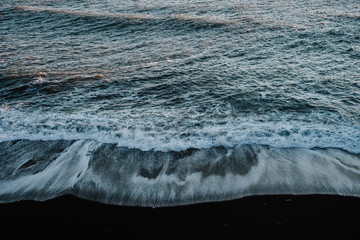 Obraz na płótnie Canvas The ocean hitting a black sand beach in Iceland