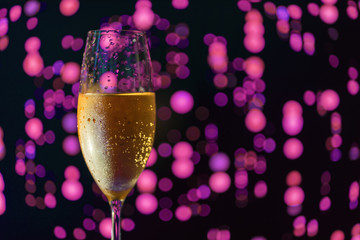 A glass of champagne on a blurred lilac background