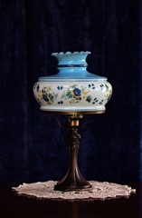 Antique blue floral hurricane lamp on crocheted doily