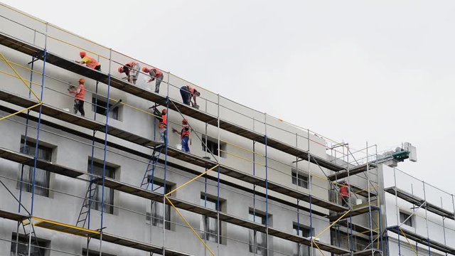Builders to plaster the wall. Men at the construction site.