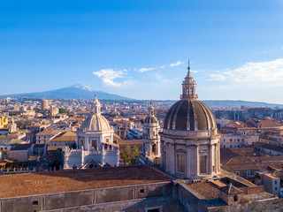 Catania, Sicily. May 10, 2018. The dome of Cathedral in Catania on the background of volcano Etna in the snow.. The view of the city of Catania with the view of Etna volcano, Sicily, Italy. 