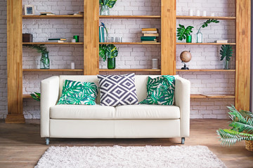 Cozy light room with plants, white sofa and stylish furniture in scandinavian style. Living room...