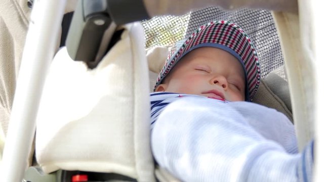 Sweet little baby boy sleeping in stroller