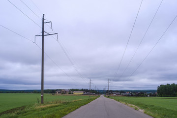 Fototapeta premium Field, the cloudy sky and country road