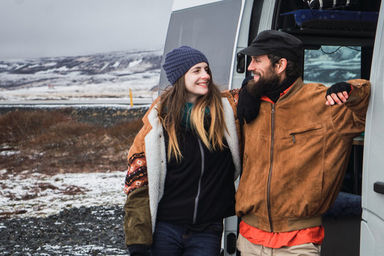 Cheerful couple with van in nature