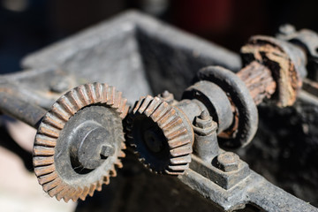 Old metal gears in drive mechanisms. Rusty gears used in machines from the last century.