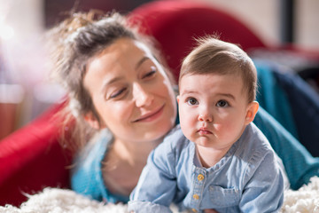 Mom plays with her cheerful baby at home