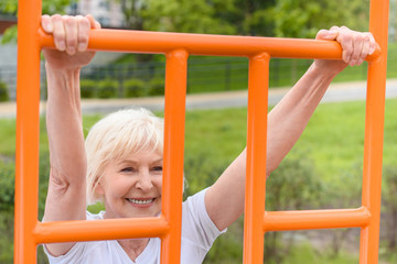 Obraz premium elderly sportswoman with grey hair exercising on sports ground
