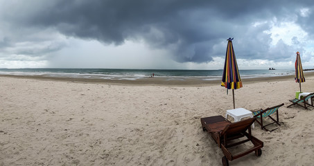 A panorama shot of a beach with imcoming rain storm / Vacation with bad weather concept