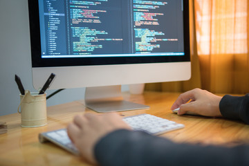 Close up hand of developing programming and coding technologies. Programmer hand typing on keyboard. Put on the wood table. Hand’s Programmer concepts.