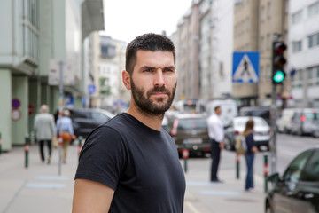 Portrait of young attractive man in the busy crowded street