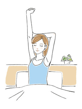 ベッドの上で背伸びをする女性