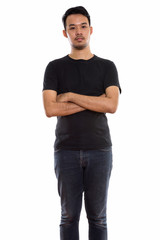 Fototapeta premium Studio shot of young Asian man standing with arms crossed