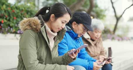 Asian Family using mobile phone in the street