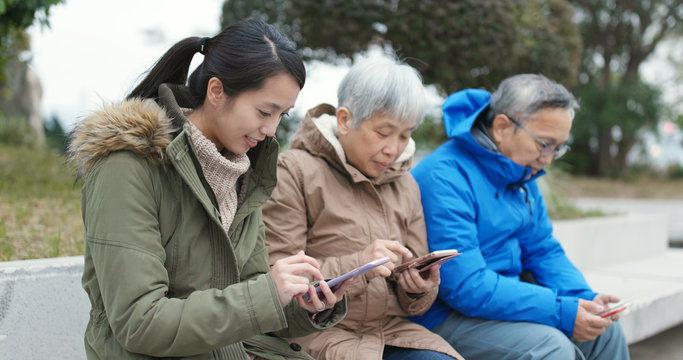 Asian Family using smart phone in the street