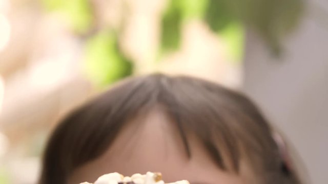 Close up of ice cream cornetto being eaten by happy young girl in italy