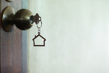 Fototapeta na wymiar Home key with house keychain in keyhole, property concept