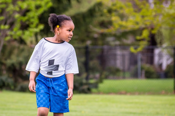 A young girl is learning how to play soccer	