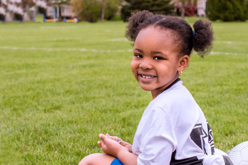 A young girl is learning how to play soccer	